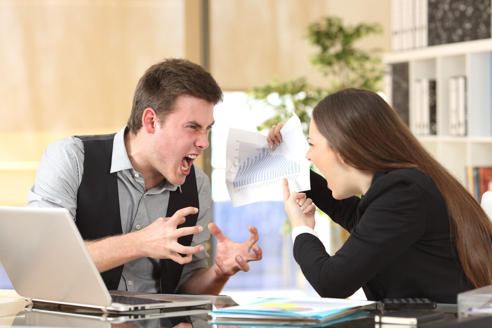 Two angry businesspeople arguing furious showing a negative growth graph at office