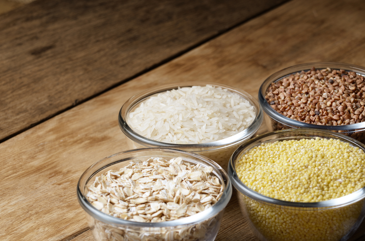 Cereal grains set in glass bowls on wooden table