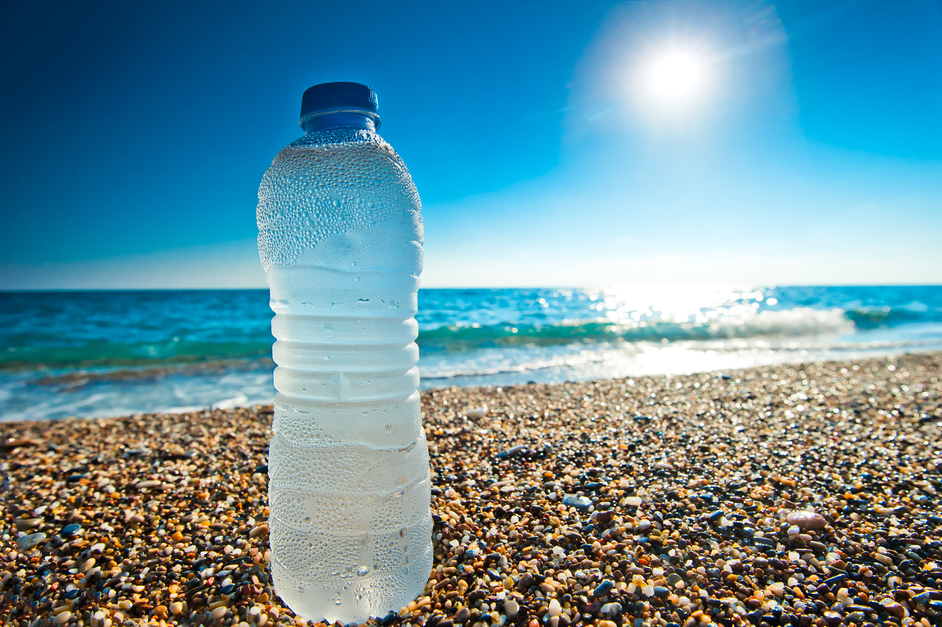 bottle of cold fresh water on the pebble beach