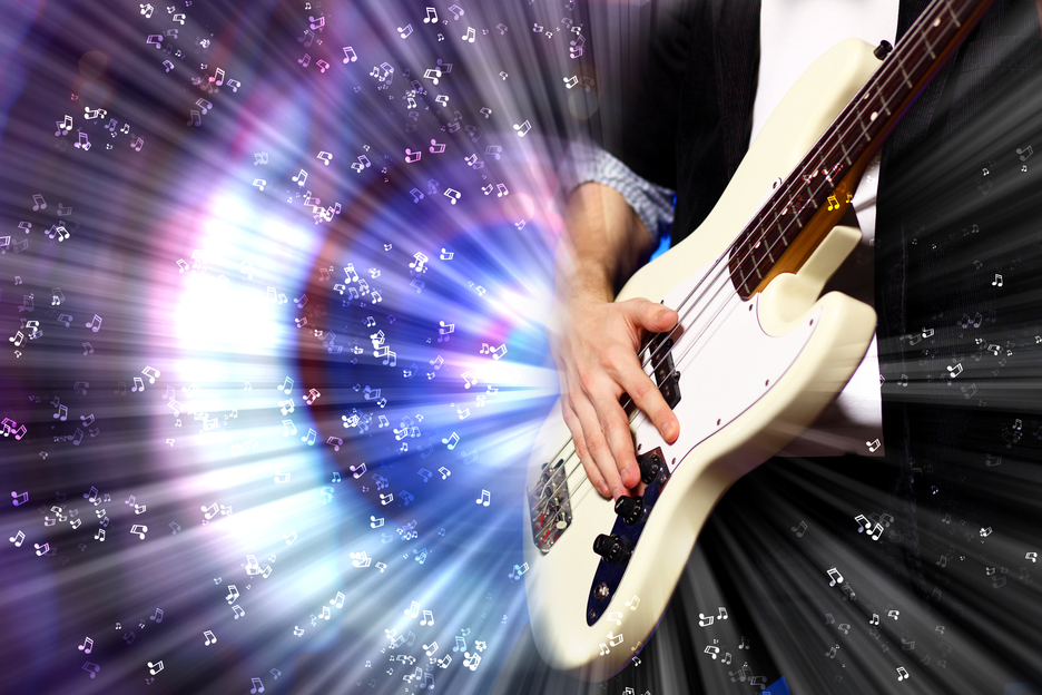 Young guitar player with instrument performing in night club