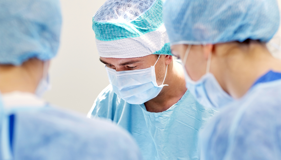 surgery, medicine and people concept - group of surgeons at operation in operating room at hospital